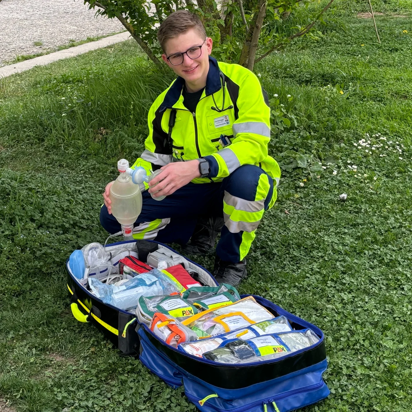 Lino neben geöffnetem Sanitätsrucksack mit Beatmungsbeutel